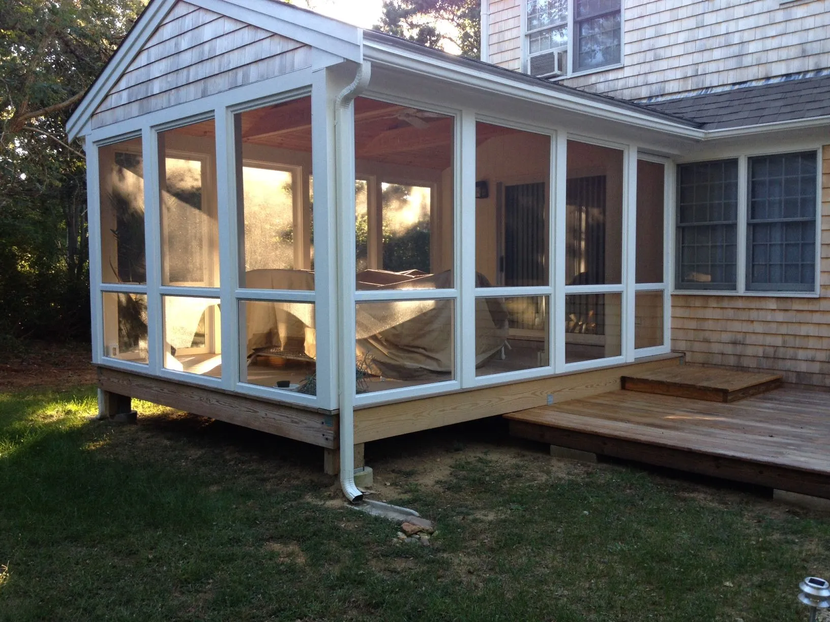 a screened in porch in the backyard of a house