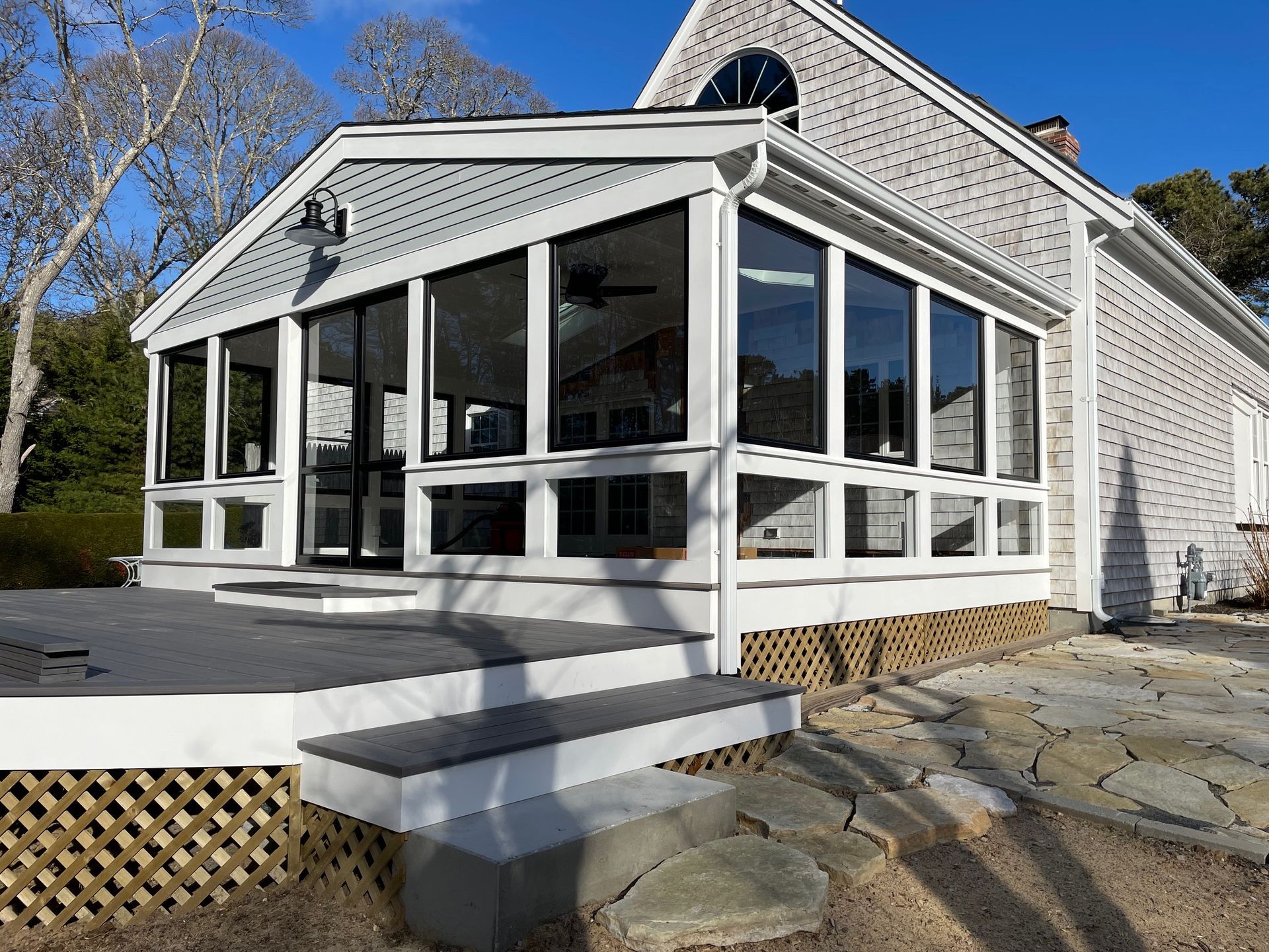 a white house with a screened in porch and stairs