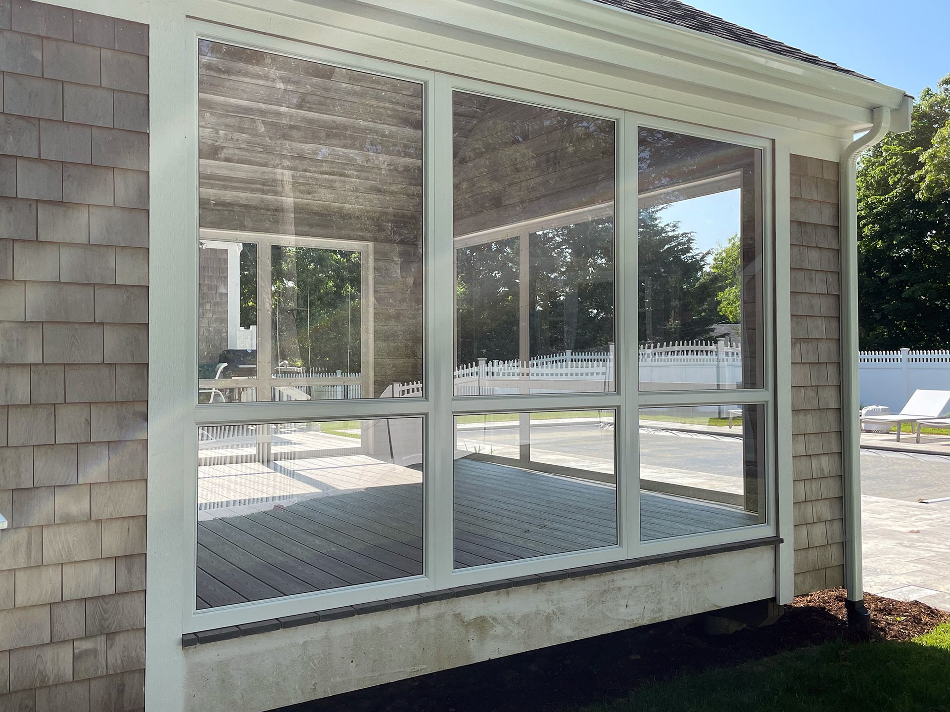 a house with a screened in porch and a large window