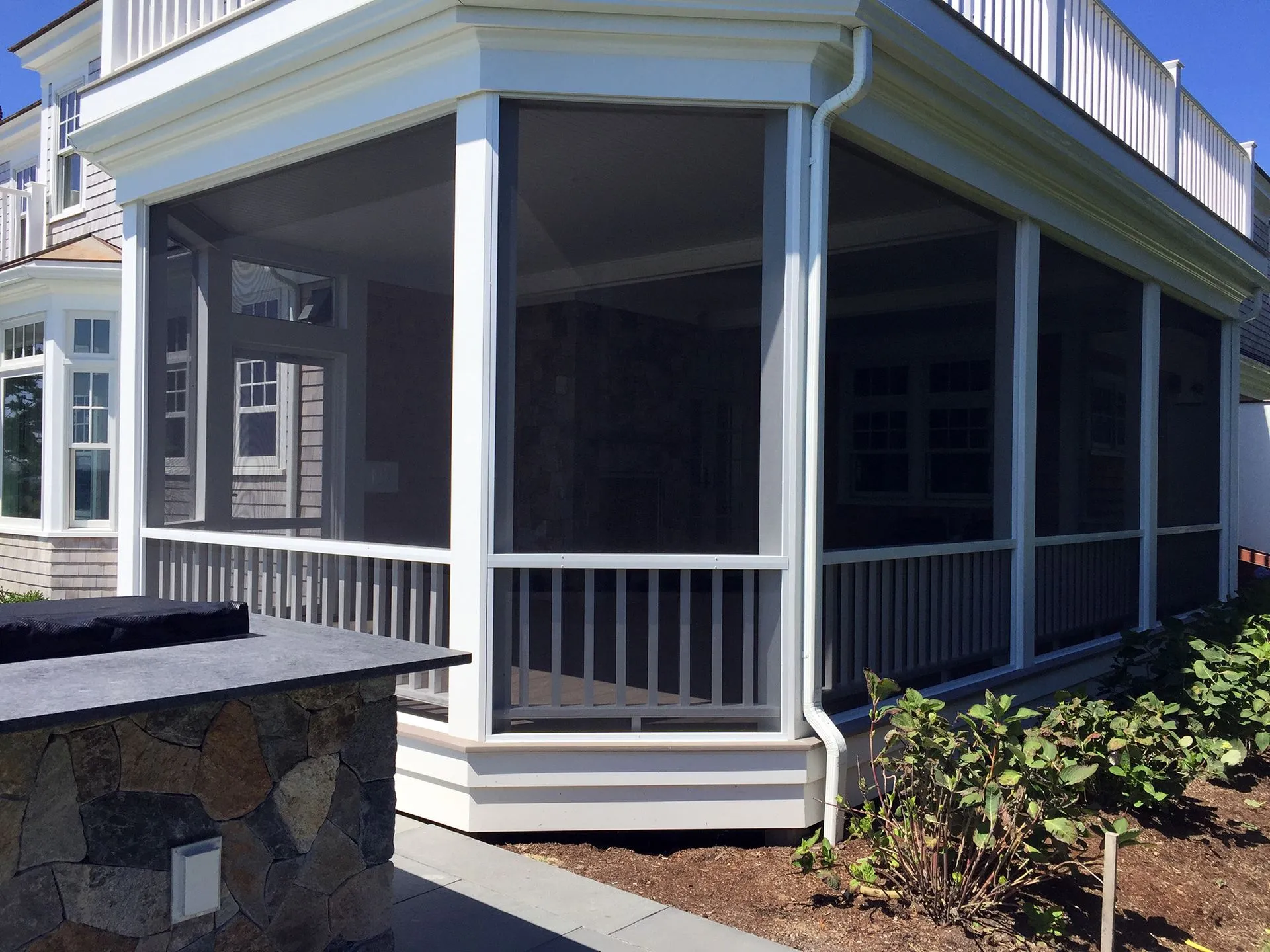 a screened in porch on the side of a house