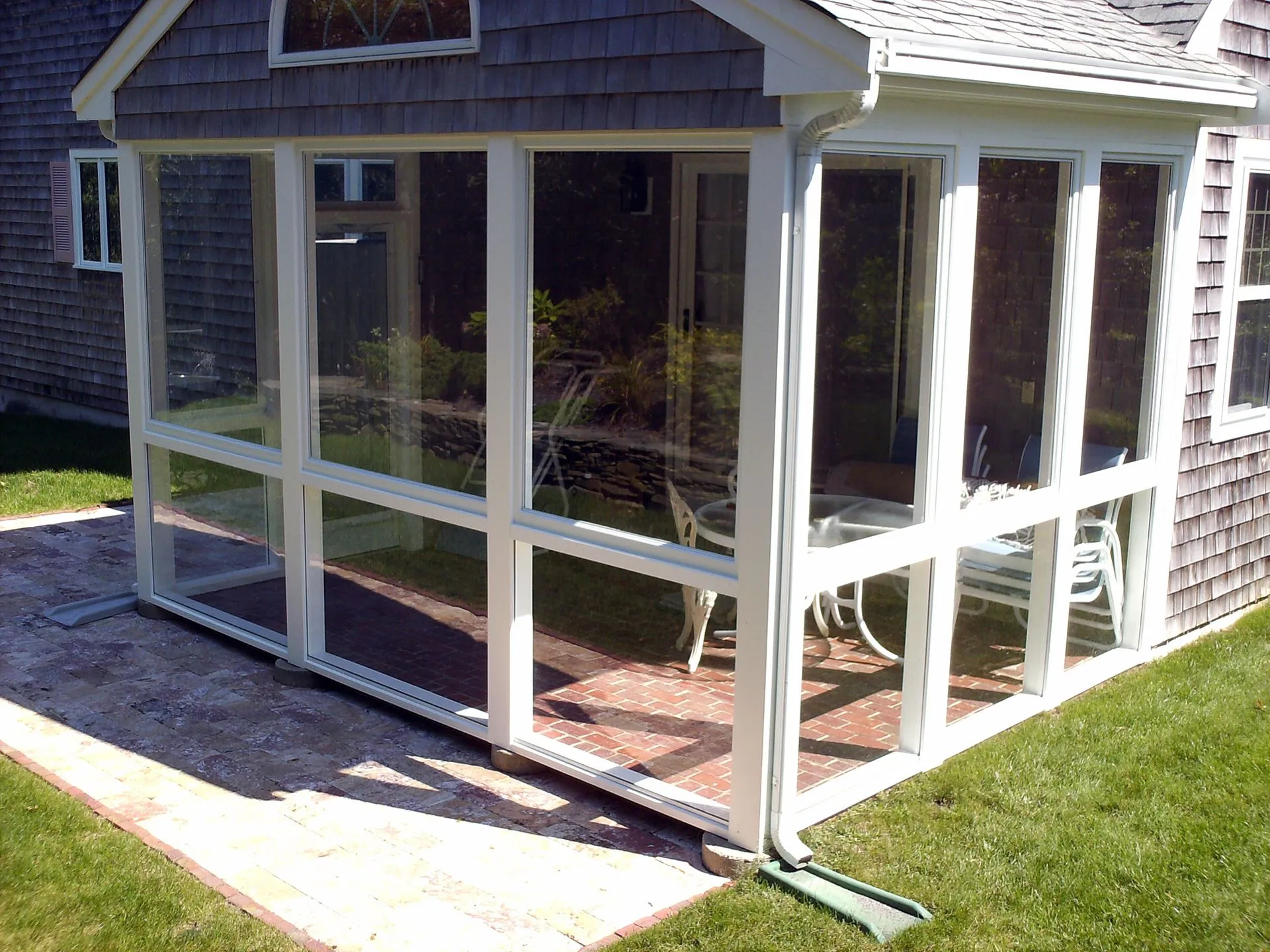 a screened in porch in the backyard of a house