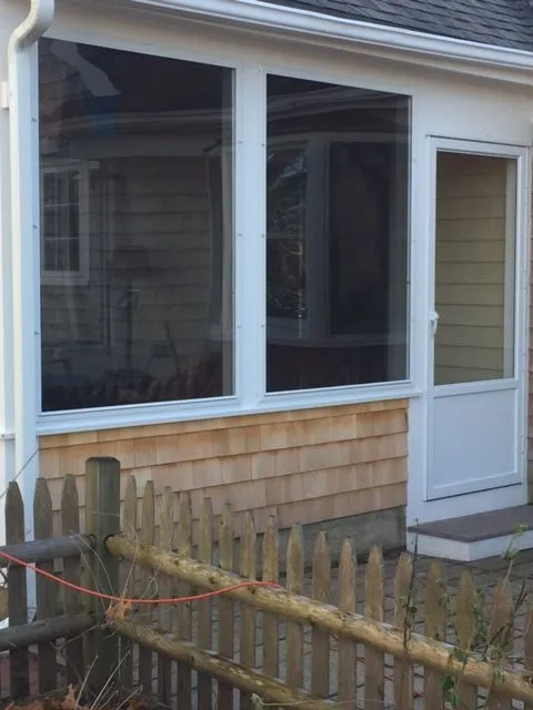 a house with a screened in porch and a wooden fence