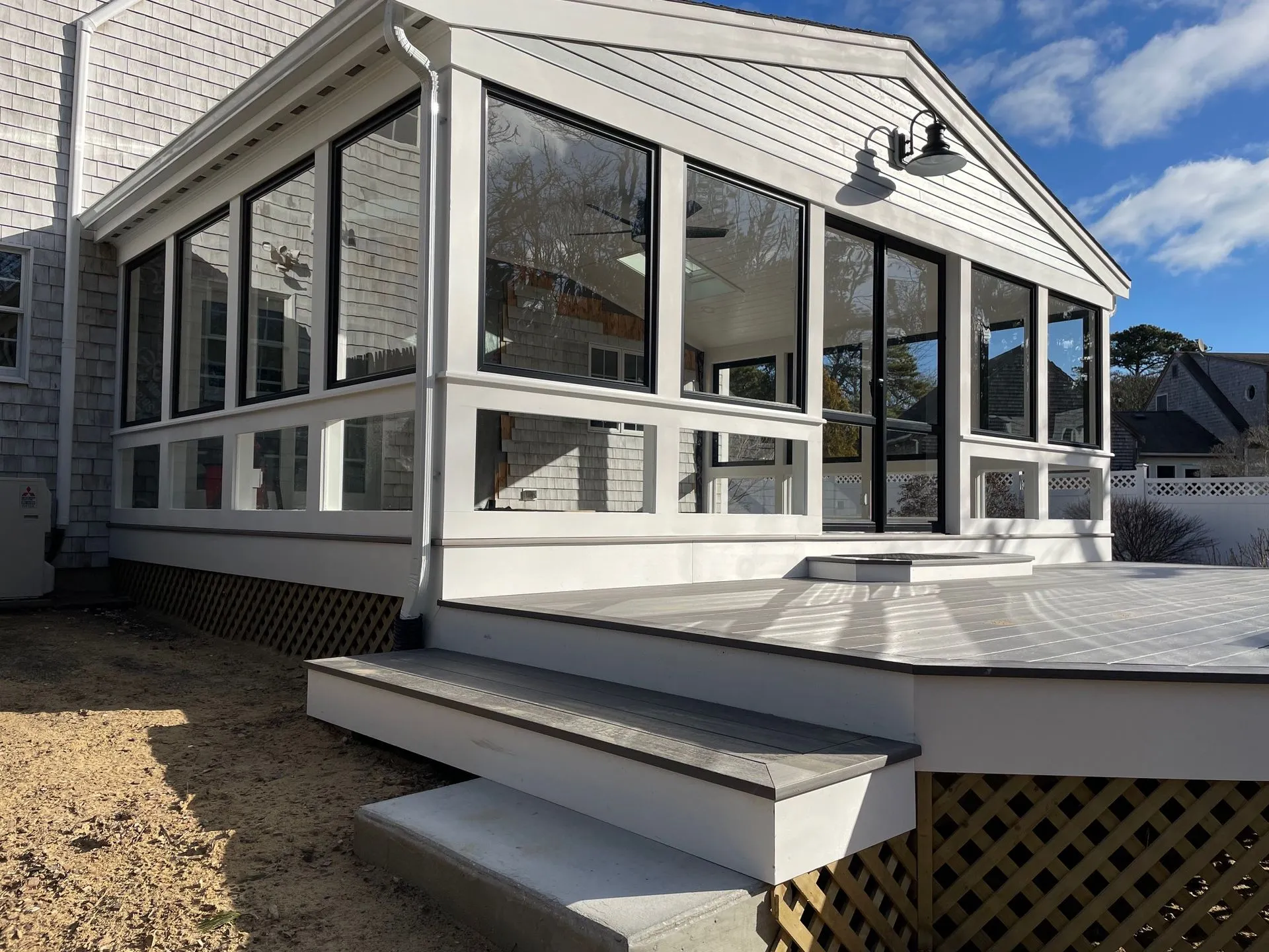 a white house with a screened in porch and stairs