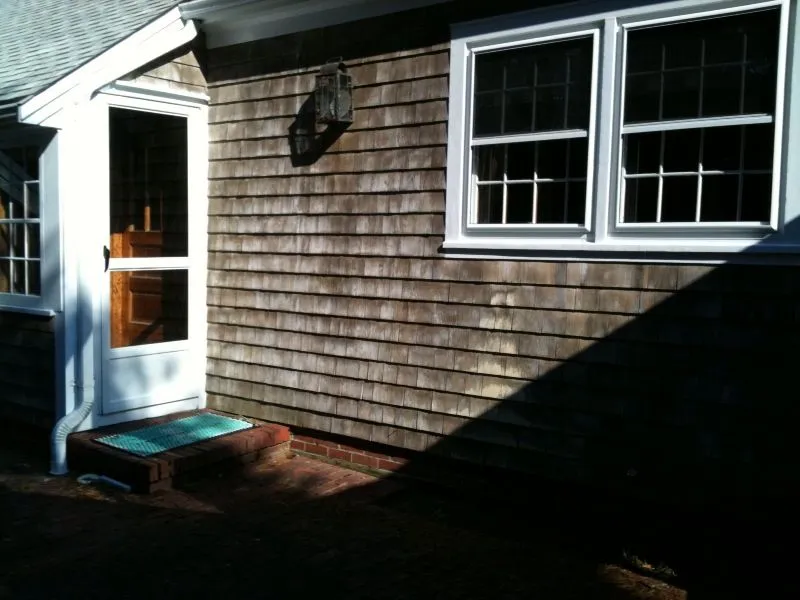a house with a wooden siding and white windows