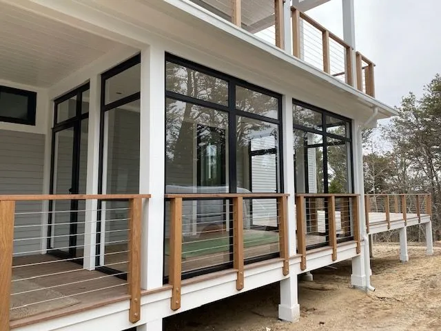 a house with a lot of windows and a wooden deck