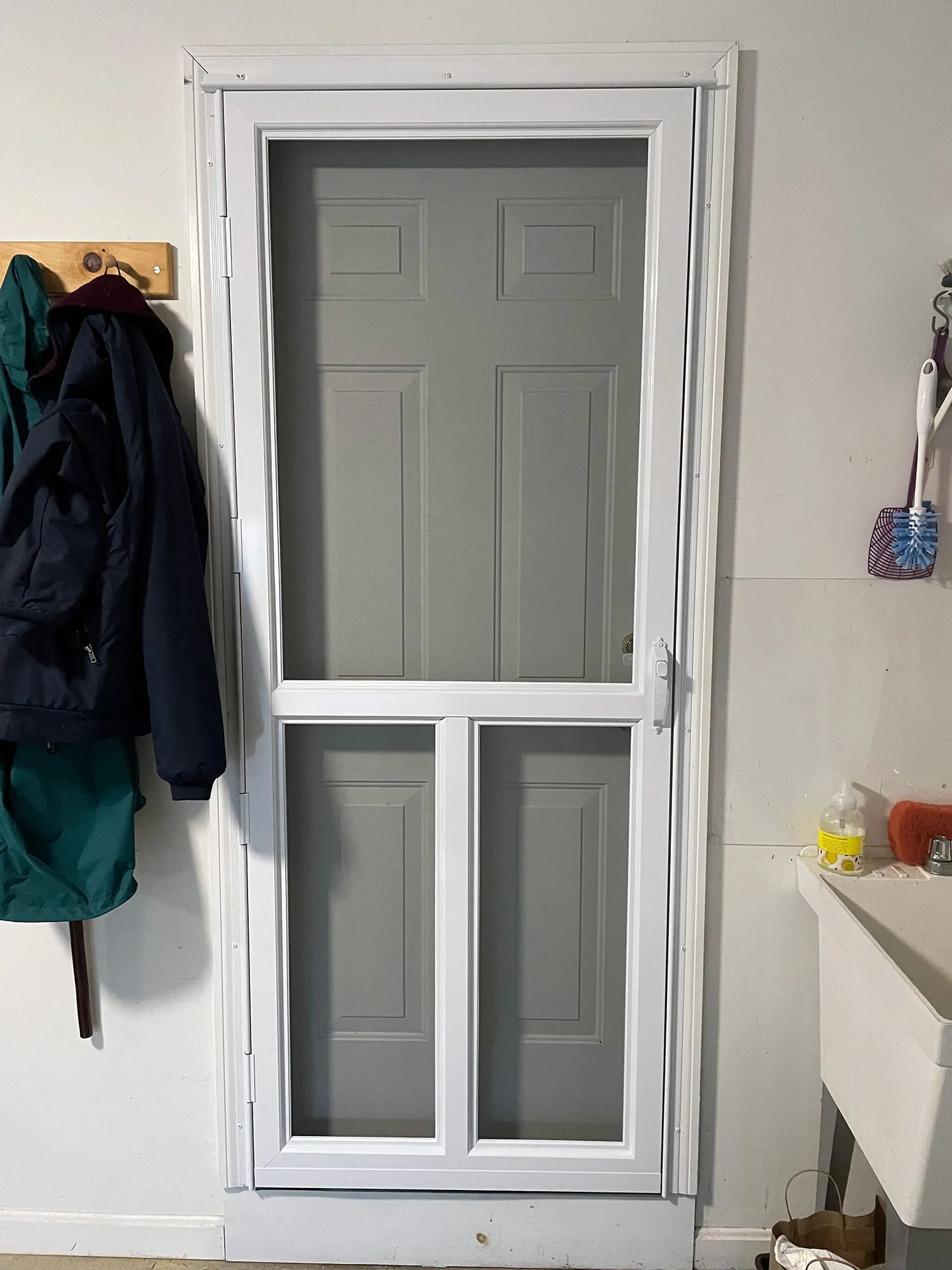 a screen door is sitting in a room next to a sink