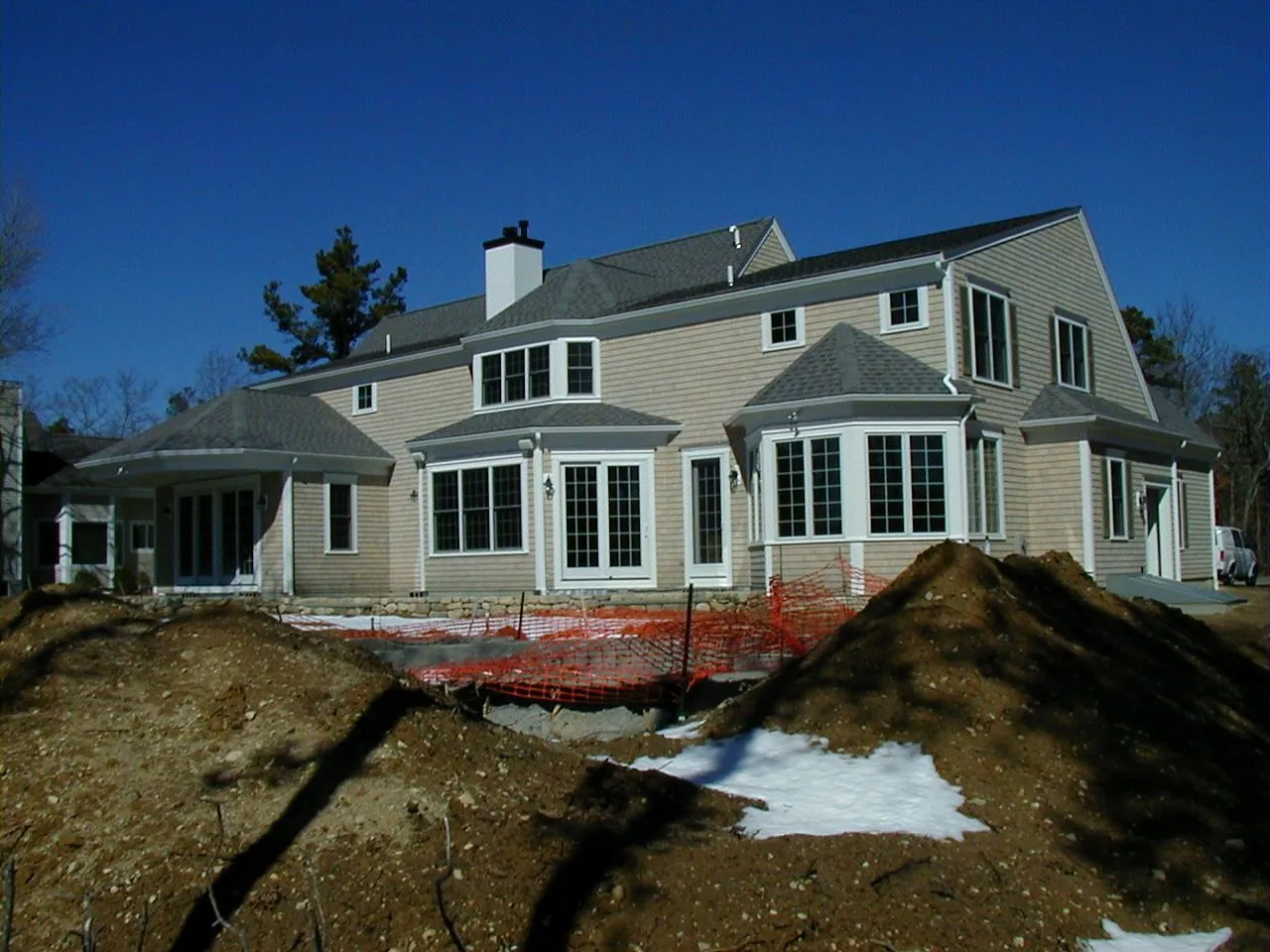 a large house is under construction with a pile of dirt in front of it