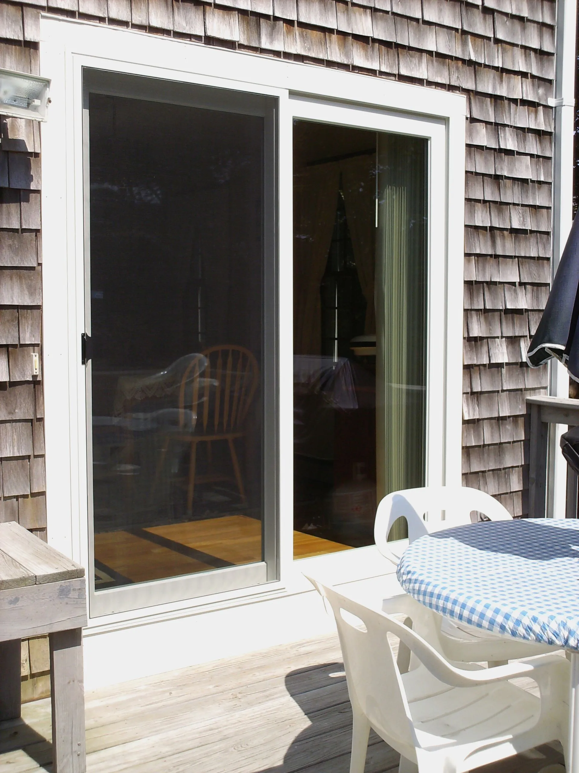 a patio with a table and chairs in front of a sliding glass door