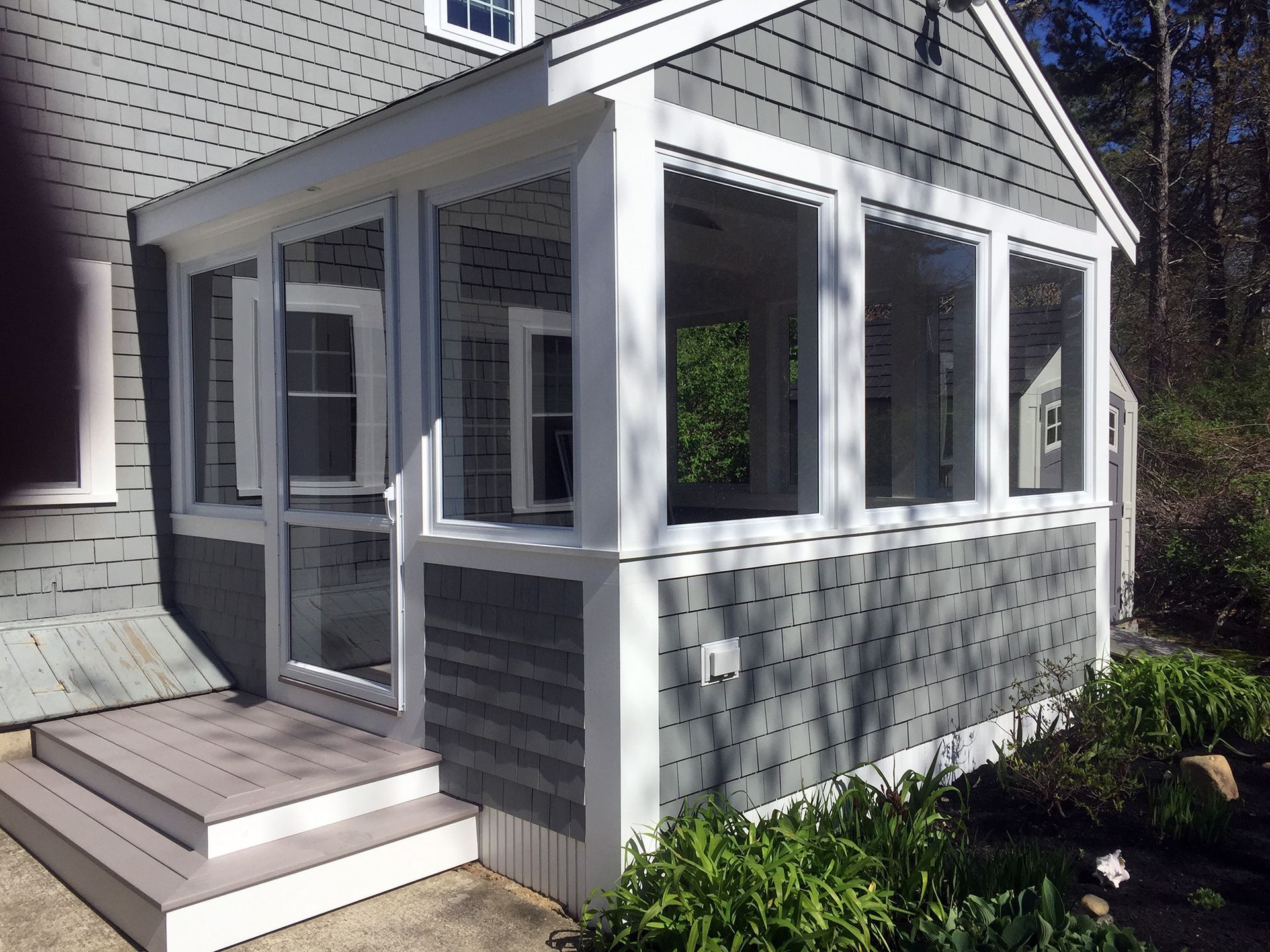 a screened in porch on the side of a house